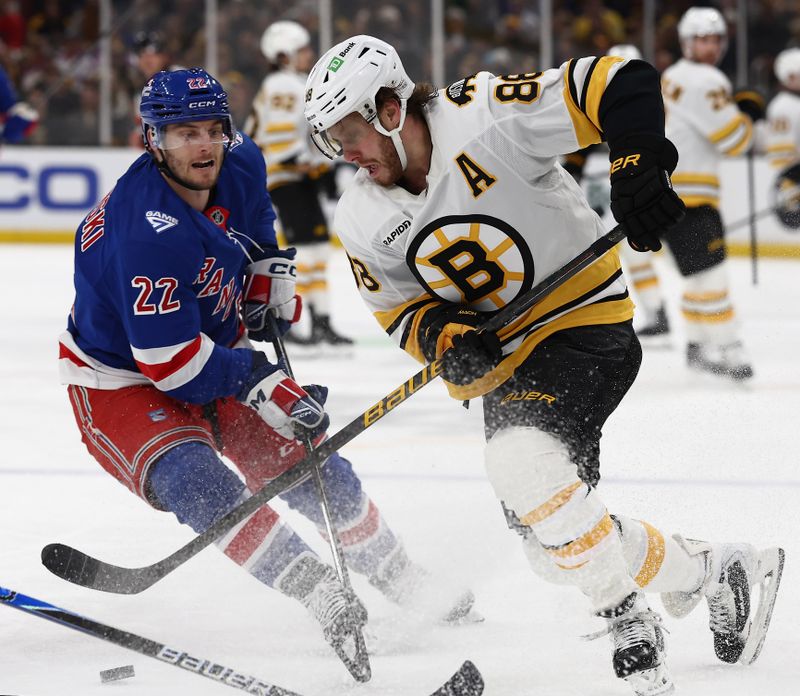 Jan 10, 2026; Boston, Massachusetts, USA; Boston Bruins right wing David Pastrnak (88) slips the puick past New York Rangers center Jonny Brodzinski (22) during the first period at TD Garden. Mandatory Credit: Winslow Townson-Imagn Images