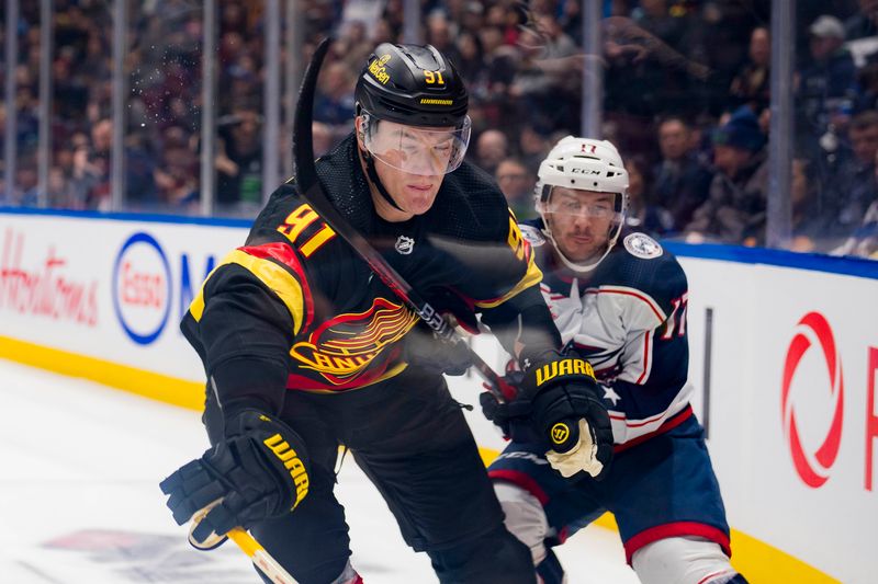 Jan 27, 2024; Vancouver, British Columbia, CAN; Vancouver Canucks defenseman Nikita Zadorov (91) battles with Columbus Blue Jackets forward Justin Danforth (17) in the first period at Rogers Arena. Mandatory Credit: Bob Frid-USA TODAY Sports