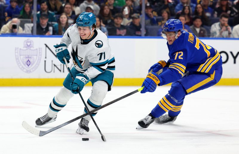 Mar 10, 2026; Buffalo, New York, USA;  Buffalo Sabres center Tage Thompson (72) knocks the puck away from San Jose Sharks center Macklin Celebrini (71) during the first period at KeyBank Center. Mandatory Credit: Timothy T. Ludwig-Imagn Images
