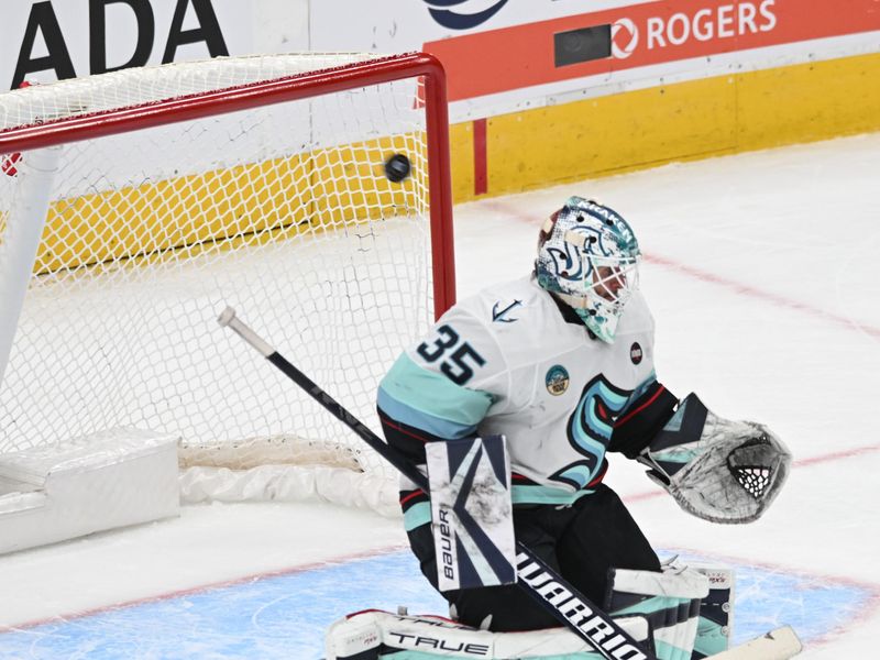 Mar 22, 2025; Edmonton, Alberta, CAN; Seattle Kraken goalie Joey Daccord (35) misses the puck as it flies behind him during the second period against the Edmonton Oilers at Rogers Place. Mandatory Credit: Walter Tychnowicz-Imagn Images