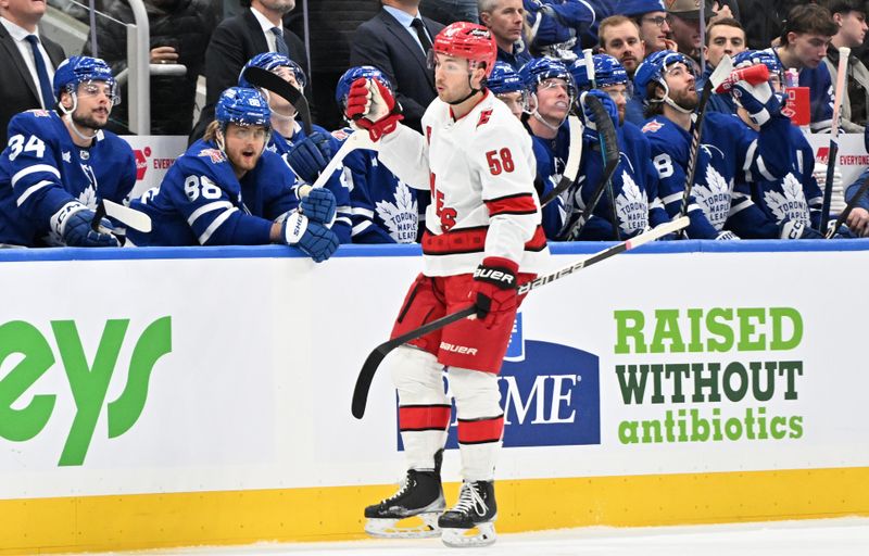 Dec 30, 2023; Toronto, Ontario, CAN; Carolina Hurricanes forward Michael Bunting (58) skates past the Toronto Maple Leafs bench as he celebrates after scoring a goal in the first period at Scotiabank Arena. Mandatory Credit: Dan Hamilton-USA TODAY Sports