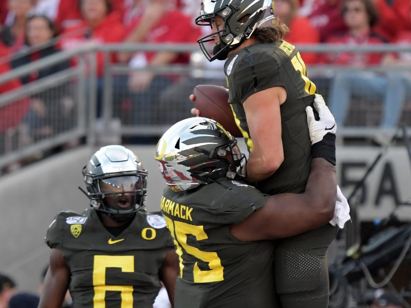 Jan 1, 2020; Pasadena, California, USA; Oregon Ducks quarterback Justin Herbert (10) celebrates scoring a touchdown with Oregon Ducks offensive lineman Dallas Warmack (75) in the second quarter against the Wisconsin Badgers during the 106th Rose Bowl game at Rose Bowl Stadium. Mandatory Credit: Kirby Lee-USA TODAY Sports