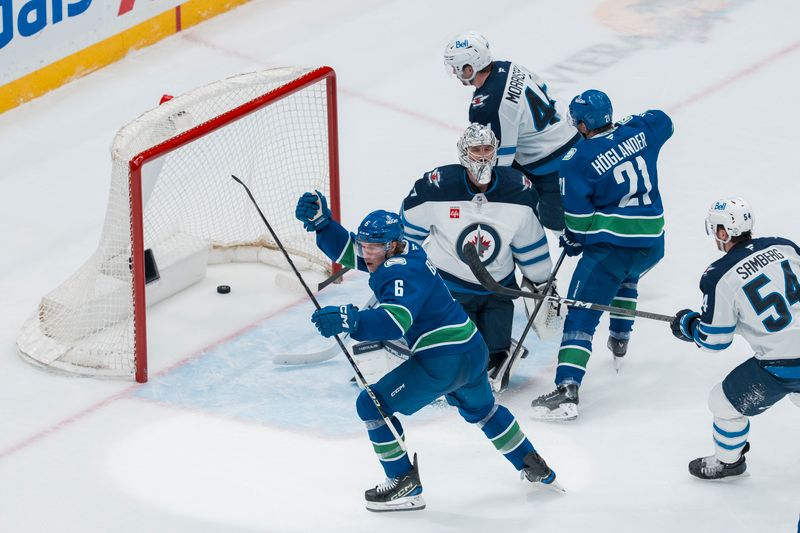 Mar 18, 2025; Vancouver, British Columbia, CAN; Winnipeg Jets defenseman Dylan Samberg (54) and defenseman Josh Morrissey (44) and Vancouver Canucks forward Nils Hoglander (21) watch as forward Brock Boeser (6) scores on goalie Connor Hellebuyck (37) in the second period at Rogers Arena. Mandatory Credit: Bob Frid-Imagn Images