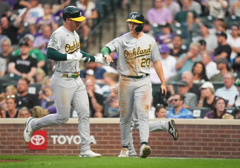 Jul 29, 2023; Denver, Colorado, USA; Oakland Athletics second baseman Zack Gelof (20) and designated hitter Brent Rooker (25) celebrate a scoring run in the sixth inning against the Colorado Rockies at Coors Field. Mandatory Credit: Ron Chenoy-USA TODAY Sports