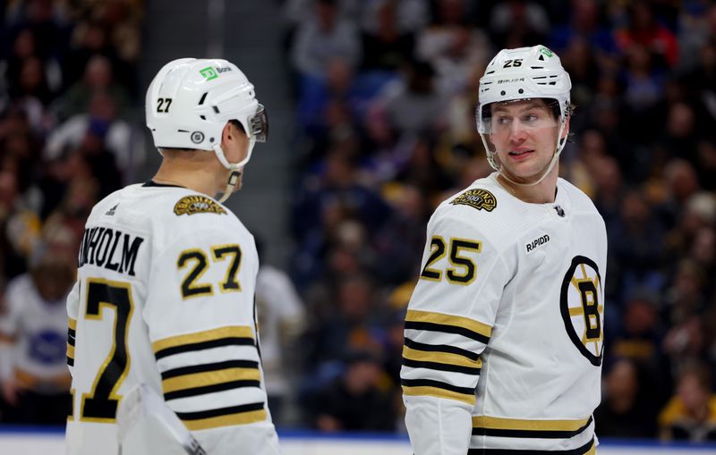 Dec 27, 2023; Buffalo, New York, USA;  Boston Bruins defenseman Hampus Lindholm (27) and defenseman Brandon Carlo (25) talk during a stoppage in play against the Buffalo Sabres during the second period at KeyBank Center. Mandatory Credit: Timothy T. Ludwig-USA TODAY Sports