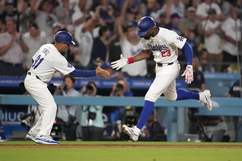 Aug 20, 2024; Los Angeles, California, USA; Los Angeles Dodgers right fielder Jason Heyward (23) celebrates with third base coach Dino Ebel (91) after hitting a three-run home run in the eighth inning against the Seattle Mariners at Dodger Stadium. Mandatory Credit: Kirby Lee-USA TODAY Sports