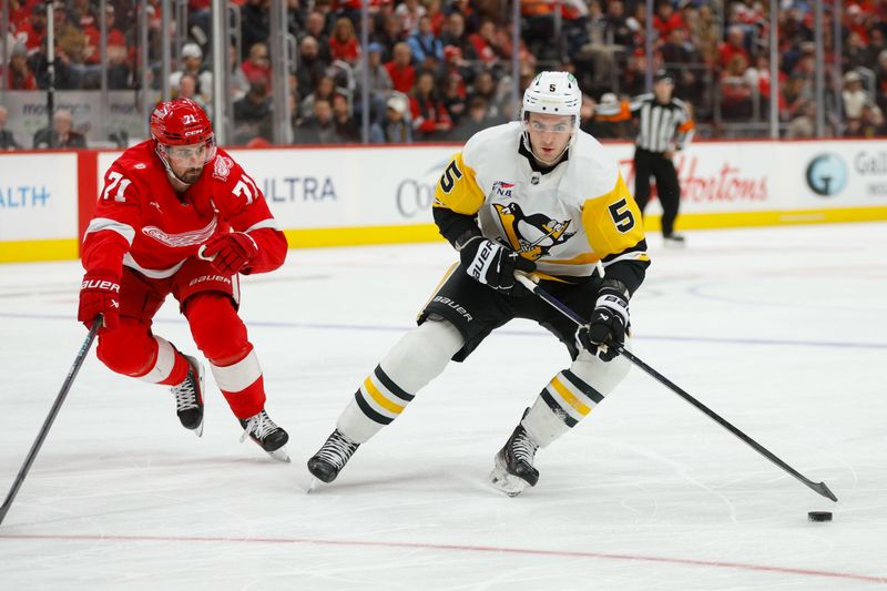 Jan 3, 2026; Detroit, Michigan, USA; Pittsburgh Penguins defenseman Ryan Shea (5) handles the puck against Detroit Red Wings center Dylan Larkin (71) during the first period at Little Caesars Arena. Mandatory Credit: Brian Bradshaw Sevald-Imagn Images