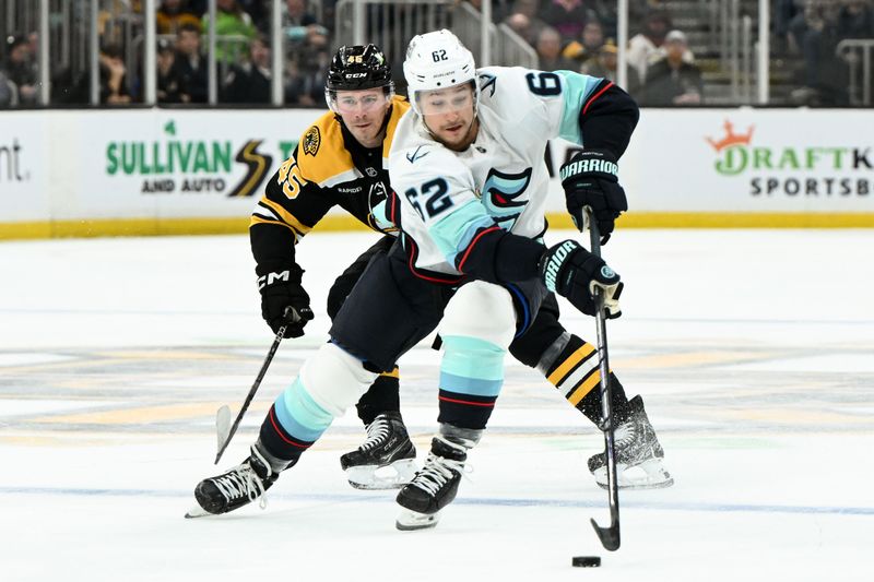 Nov 3, 2024; Boston, Massachusetts, USA; Seattle Kraken defenseman Brandon Montour (62) controls the puck against Boston Bruins left wing Cole Koepke (45)  during the second period at the TD Garden. Mandatory Credit: Brian Fluharty-Imagn Images