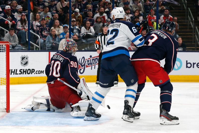 Nov 1, 2024; Columbus, Ohio, USA; Columbus Blue Jackets goalie Elvis Merzlikins (90) makes a save as Winnipeg Jets right wing Nino Niederreiter (62) looks for a rebound during the third period at Nationwide Arena. Mandatory Credit: Russell LaBounty-Imagn Images