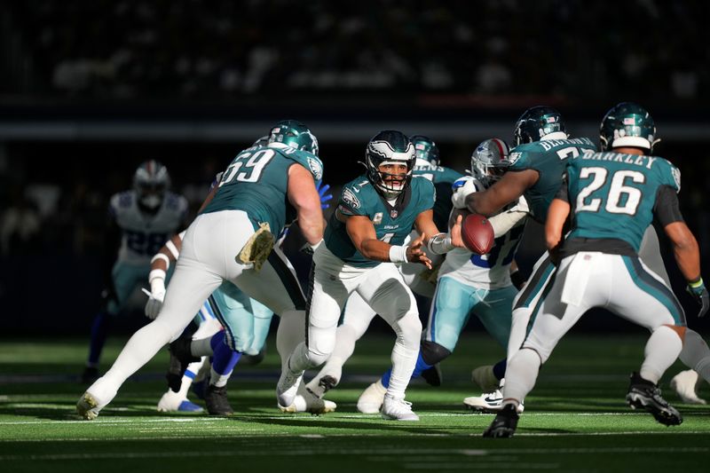 Philadelphia Eagles quarterback Jalen Hurts (1) pitches the ball to Saquon Barkley (26) in the first half of an NFL football game against the Dallas Cowboys in Arlington, Texas, Sunday, Nov. 10, 2024. (AP Photo/Jeffrey McWhorter)