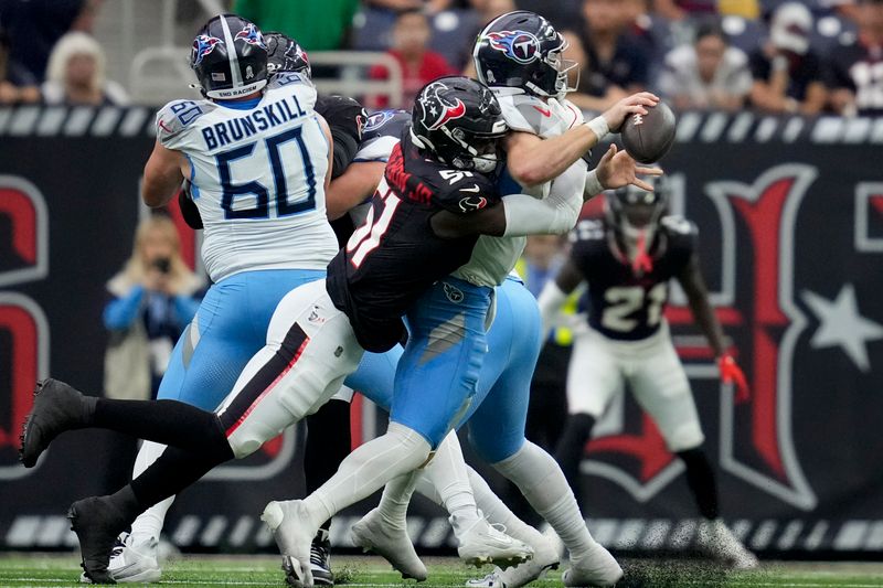 Houston Texans defensive end Will Anderson Jr., left, sacks Tennessee Titans quarterback Will Levis, right, during the first half of an NFL football game Sunday, Nov. 24, 2024, in Houston. (AP Photo/Ashley Landis)