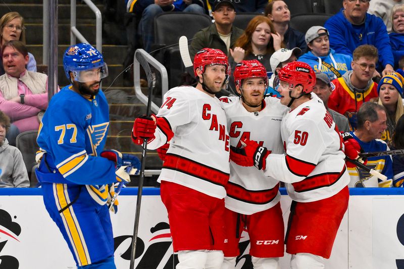 Oct 19, 2024; St. Louis, Missouri, USA;  Carolina Hurricanes center Jack Roslovic (96) is congratulated by defenseman Jaccob Slavin (74) and left wing Eric Robinson (50) after scoring against the St. Louis Blues during the third period at Enterprise Center. Mandatory Credit: Jeff Curry-Imagn Images