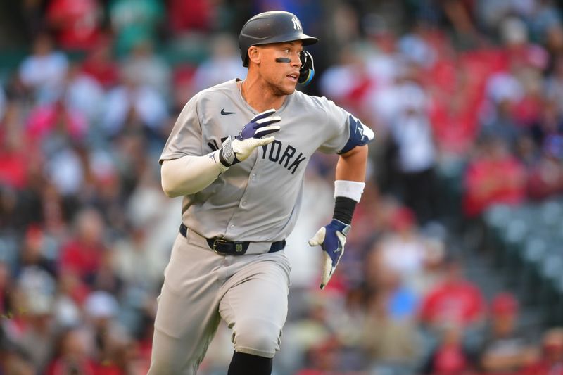May 27, 2025; Anaheim, California, USA; New York Yankees right fielder Aaron Judge (99) runs after hitting a single against the Los Angeles Angels during the first inning at Angel Stadium. Mandatory Credit: Gary A. Vasquez-Imagn Images
