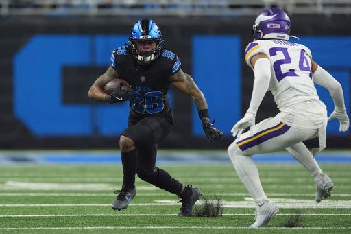 Detroit Lions running back Jahmyr Gibbs (26) runs against Minnesota Vikings safety Camryn Bynum (24) during the first half of an NFL football game Sunday, Jan. 5, 2025, in Detroit. (AP Photo/Charlie Riedel)