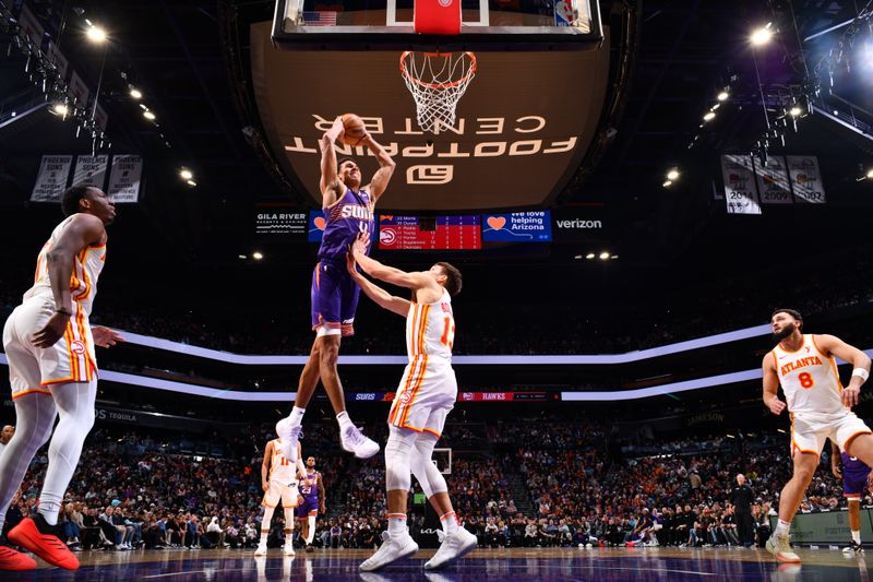 PHOENIX, AZ - JANUARY 9: Oso Ighodaro #4 of the Phoenix Suns dunks the ball during the game against the Atlanta Hawks on January 9, 2025 at Footprint Center in Phoenix, Arizona. NOTE TO USER: User expressly acknowledges and agrees that, by downloading and or using this photograph, user is consenting to the terms and conditions of the Getty Images License Agreement. Mandatory Copyright Notice: Copyright 2025 NBAE (Photo by Barry Gossage/NBAE via Getty Images)