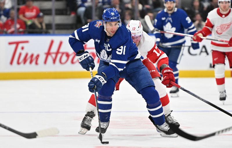 Jan 14, 2024; Toronto, Ontario, CAN;  Toronto Maple Leafs forward John Tavares (91) skates with the puck as Detroit Red Wings forward Andrew Copp (17) pursues in the third period at Scotiabank Arena. Mandatory Credit: Dan Hamilton-USA TODAY Sports