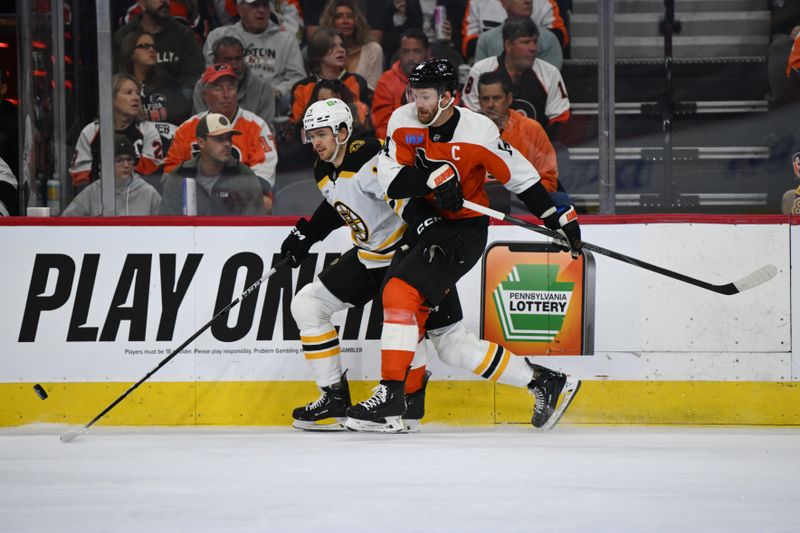 Nov 2, 2024; Philadelphia, Pennsylvania, USA; Boston Bruins center John Beecher (19) and Philadelphia Flyers center Sean Couturier (14) battle for the puck in the first period at Wells Fargo Center. Mandatory Credit: Kyle Ross-Imagn Images