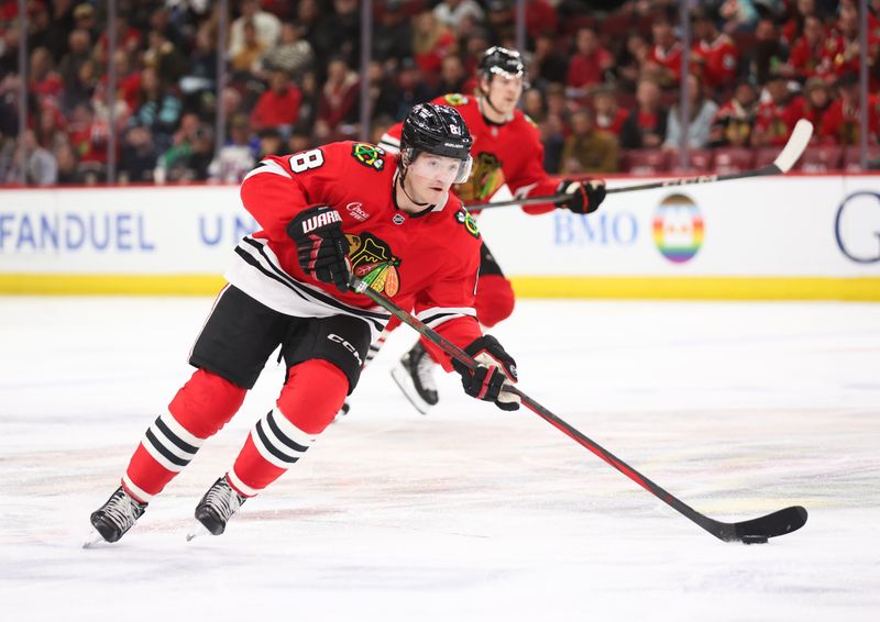 Mar 18, 2025; Chicago, Illinois, USA; Chicago Blackhawks center Ryan Donato (8) skates with the puck during the second period against the Seattle Kraken at United Center. Mandatory Credit: Talia Sprague-Imagn Images