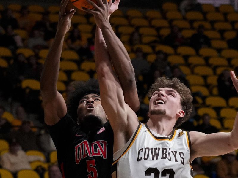 Feb 27, 2024; Laramie, Wyoming, USA; UNLV Runnin' Rebels guard Rob Whaley Jr. (5) battles for a rebound against Wyoming Cowboys forward Mason Walters (33) during the first half at Arena-Auditorium. Mandatory Credit: Troy Babbitt-USA TODAY Sports