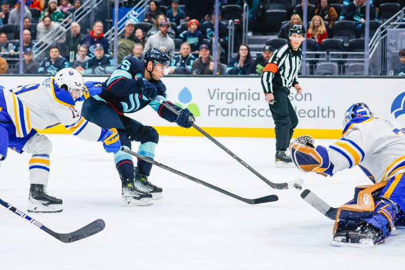Jan 20, 2025; Seattle, Washington, USA; Seattle Kraken left wing Andre Burakovsky (95) attempts a shot against Buffalo Sabres goaltender Devon Levi (27) during the first period at Climate Pledge Arena. Mandatory Credit: Joe Nicholson-Imagn Images