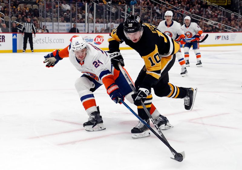 Feb 20, 2024; Pittsburgh, Pennsylvania, USA; New York Islanders defenseman Scott Mayfield (24) defends Pittsburgh Penguins left wing Drew O'Connor (10) during the third period at PPG Paints Arena. New York won 5-4 in overtime. Mandatory Credit: Charles LeClaire-USA TODAY Sports