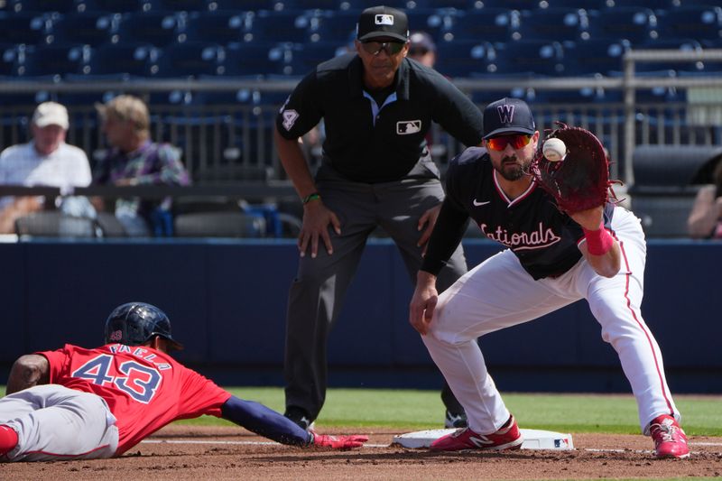 Feb 28, 2024; West Palm Beach, Florida, USA;  Washington Nationals first baseman Joey Gallo (24) receives a throw from pitcher Jackson Rutledge as Boston Red Sox outfielder Ceddanne Rafaela (43) dives back into first base in the first inning at The Ballpark of the Palm Beaches. Mandatory Credit: Jim Rassol-USA TODAY Sports