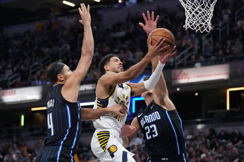 INDIANAPOLIS, INDIANA - NOVEMBER 06: Tyrese Haliburton #0 of the Indiana Pacers attempts a shot while being guarded by Jalen Suggs #4 and Tristan da Silva #23 of the Orlando Magic in the fourth quarter at Gainbridge Fieldhouse on November 06, 2024 in Indianapolis, Indiana. NOTE TO USER: User expressly acknowledges and agrees that, by downloading and or using this photograph, User is consenting to the terms and conditions of the Getty Images License Agreement. (Photo by Dylan Buell/Getty Images)