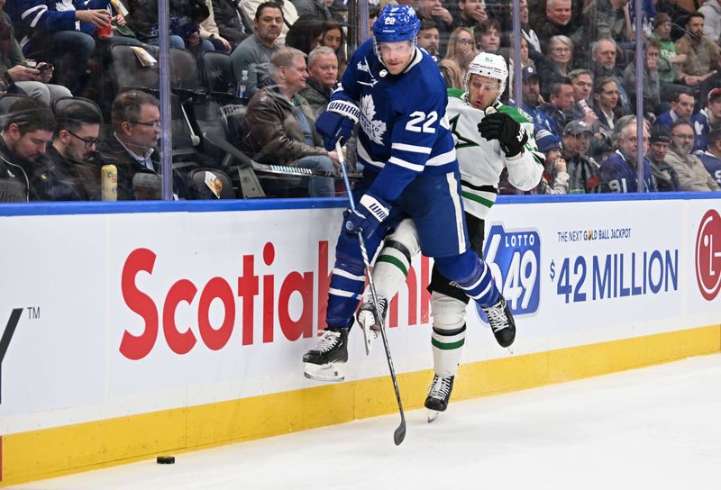 Feb 7, 2024; Toronto, Ontario, CAN; Toronto Maple Leafs defenseman Jake McCabe (22) pursus the puck ahead of Dallas Stars forward Evgenii Dadonov (63) in the second period at Scotiabank Arena. Mandatory Credit: Dan Hamilton-USA TODAY Sports