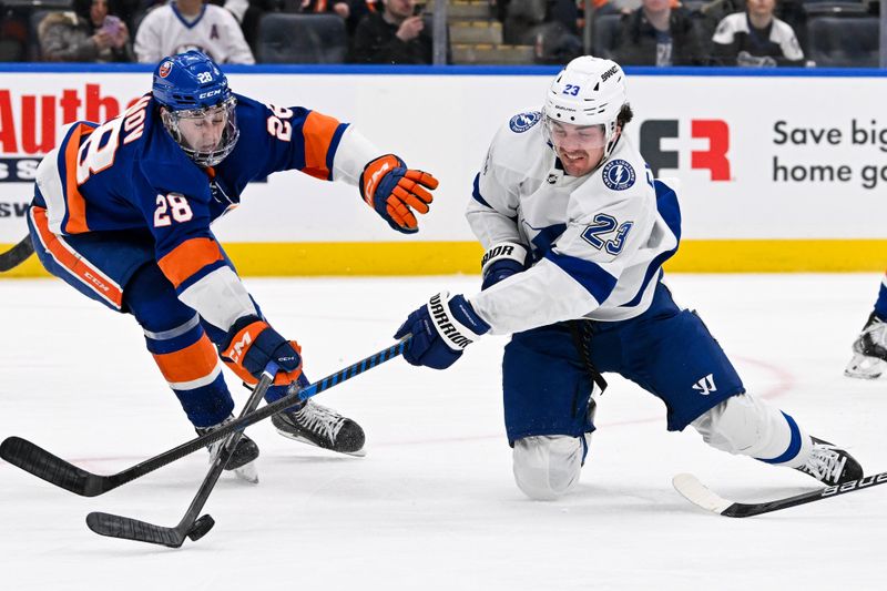 Feb 8, 2024; Elmont, New York, USA; Tampa Bay Lightning center Michael Eyssimont (23) attempts a shot defended by New York Islanders defenseman Alexander Romanov (28) during the third period at UBS Arena. Mandatory Credit: Dennis Schneidler-USA TODAY Sports