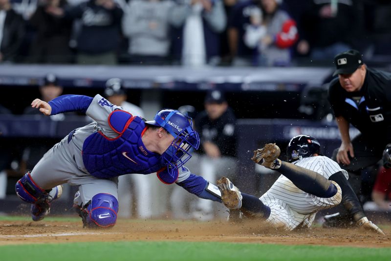 Oct 29, 2024; New York, New York, USA; New York Yankees shortstop Anthony Volpe (11) scores against Los Angeles Dodgers catcher Will Smith (16) during the eighth inning in game four of the 2024 MLB World Series at Yankee Stadium. Mandatory Credit: Brad Penner-Imagn Images