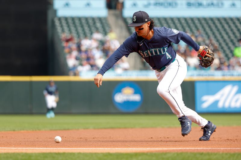 Sep 19, 2024; Seattle, Washington, USA; Seattle Mariners third baseman Josh Rojas (4) recovers a ground ball after committing an error against the New York Yankees during the first inning at T-Mobile Park. Mandatory Credit: Joe Nicholson-Imagn Images