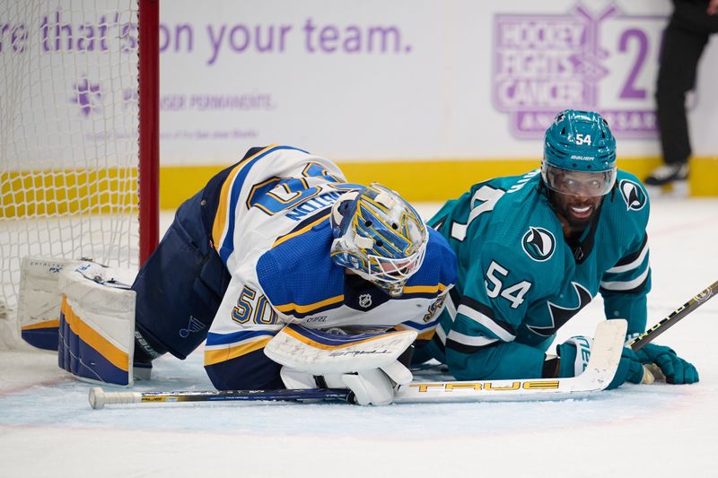 Nov 16, 2023; San Jose, California, USA; San Jose Sharks right wing Givani Smith (54) lies on the ice in the goal crease with St. Louis Blues goaltender Jordan Binnington (50) during the second period at SAP Center at San Jose. Mandatory Credit: Robert Edwards-USA TODAY Sports