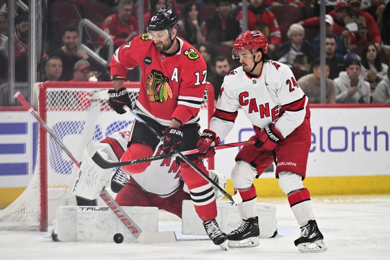 Apr 14, 2024; Chicago, Illinois, USA; Chicago Blackhawks forward Nick Foligno (17) and Carolina Hurricanes forward Seth Jarvis (24) battle for control of the puck in front of the net in the first period at United Center. Mandatory Credit: Jamie Sabau-USA TODAY Sports