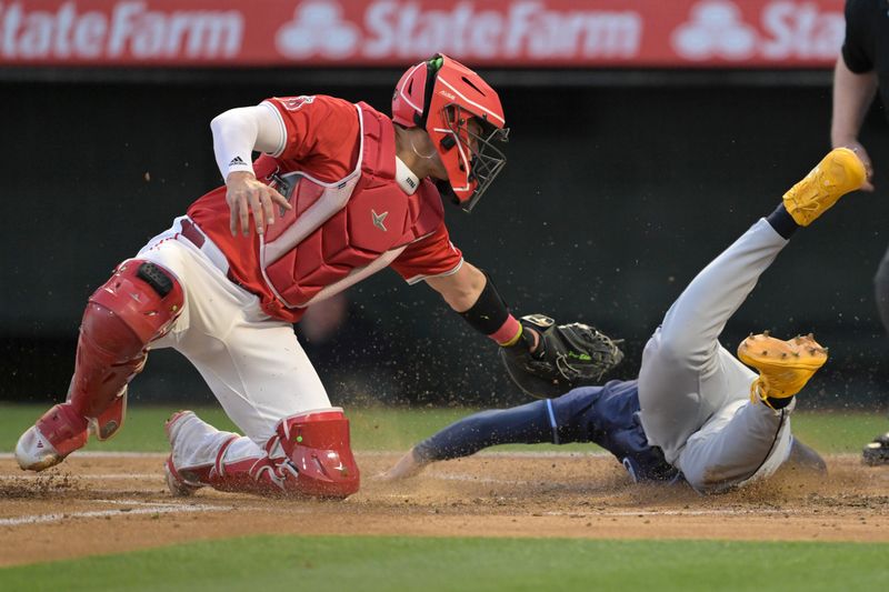 Apr 9, 2024; Anaheim, California, USA;  Tampa Bay Rays outfielder Jose Siri (22) beats the tag by Los Angeles Angels catcher Logan O'Hoppe (14) to score a run in the second inning at Angel Stadium. Mandatory Credit: Jayne Kamin-Oncea-USA TODAY Sports