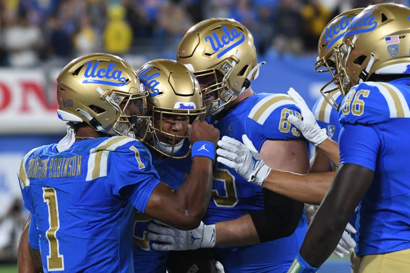 Sep 18, 2021; Pasadena, California, USA; UCLA Bruins running back Zach Charbonnet (24) celebrates with quarterback Dorian Thompson-Robinson (1) and offensive lineman Paul Grattan (65) after running for a touchdown against the Fresno State Bulldogs in the first quarter at Rose Bowl. Mandatory Credit: Richard Mackson-USA TODAY Sports