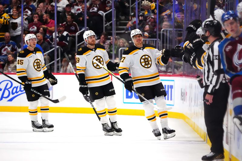 Oct 16, 2024; Denver, Colorado, USA; Boston Bruins defenseman Hampus Lindholm (27) celebrates his goal with center John Beecher (19) and left wing Cole Koepke (45) in the second period against the Colorado Avalanche at Ball Arena. Mandatory Credit: Ron Chenoy-Imagn Images