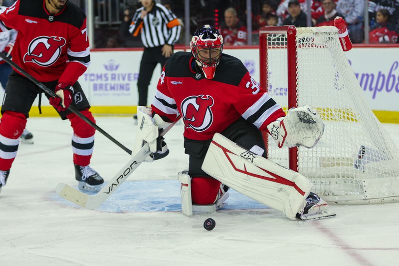 Nov 30, 2024; Newark, New Jersey, USA; New Jersey Devils goaltender Jake Allen (34) track the puck in front of the goal against the Washington Capitals during the first period at Prudential Center. Mandatory Credit: Thomas Salus-Imagn Images