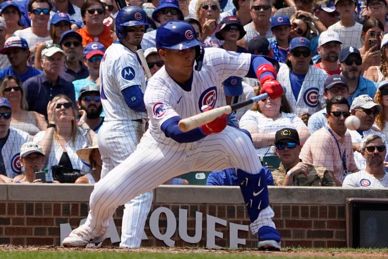 Aug 3, 2024; Chicago, Illinois, USA; Chicago Cubs catcher Miguel Amaya (9) lays down a one-run sacrifice bunt against the St. Louis Cardinals during the second inning at Wrigley Field. Mandatory Credit: David Banks-USA TODAY Sports