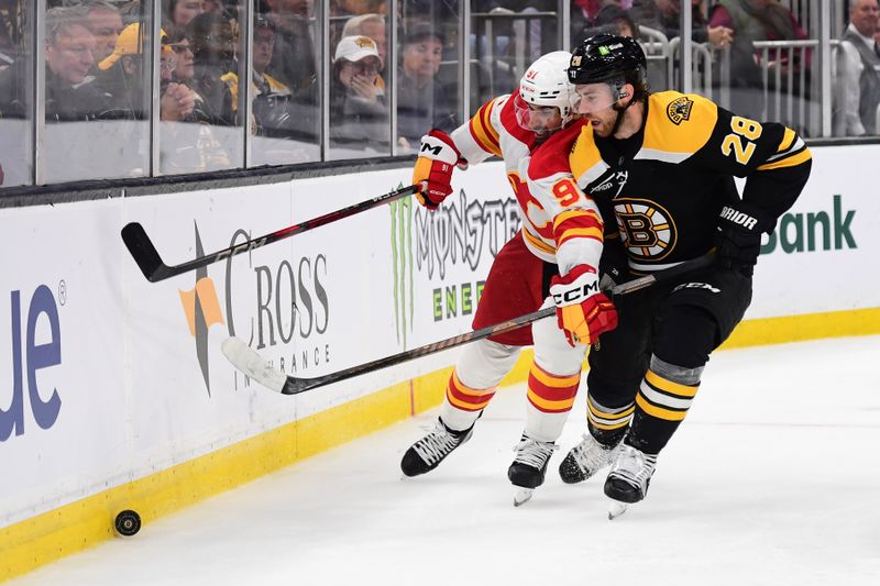 Nov 7, 2024; Boston, Massachusetts, USA;  Calgary Flames center Nazem Kadri (91) and Boston Bruins center Elias Lindholm (28) battle for the puck during overtime at TD Garden. Mandatory Credit: Bob DeChiara-Imagn Images