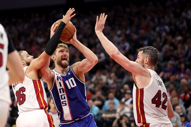 SACRAMENTO, CALIFORNIA - FEBRUARY 26: Domantas Sabonis #10 of the Sacramento Kings goes up for a shot on Caleb Martin #16 and Kevin Love #42 of the Miami Heat in the first half at Golden 1 Center on February 26, 2024 in Sacramento, California. NOTE TO USER: User expressly acknowledges and agrees that, by downloading and or using this photograph, User is consenting to the terms and conditions of the Getty Images License Agreement.  (Photo by Ezra Shaw/Getty Images)