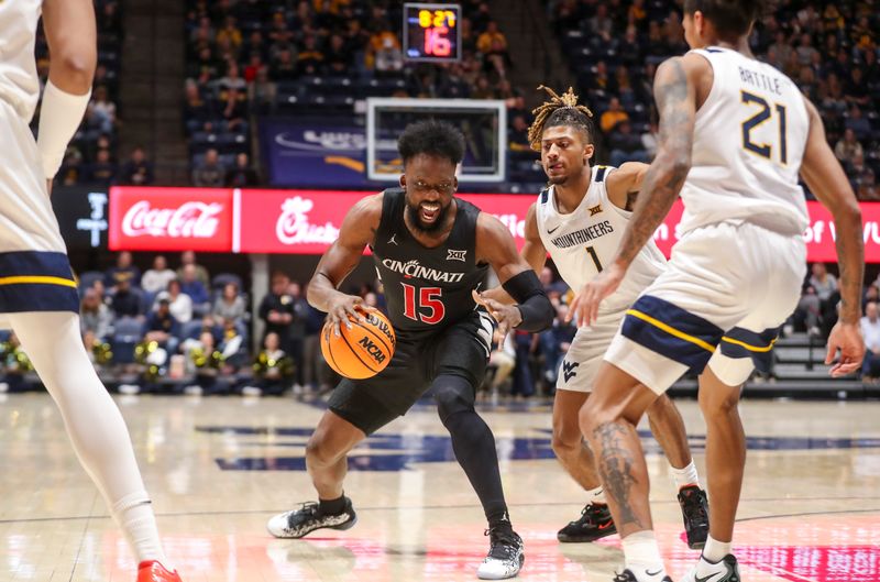 Jan 31, 2024; Morgantown, West Virginia, USA; Cincinnati Bearcats forward John Newman III (15) drives against West Virginia Mountaineers guard Noah Farrakhan (1) during the first half at WVU Coliseum. Mandatory Credit: Ben Queen-USA TODAY Sports