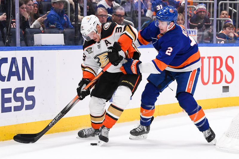 Dec 13, 2023; Elmont, New York, USA; Anaheim Ducks right wing Jakob Silfverberg (33) and New York Islanders defenseman Mike Reilly (2) battle for a loss puck behind the net during the third period at UBS Arena. Mandatory Credit: Dennis Schneidler-USA TODAY Sports