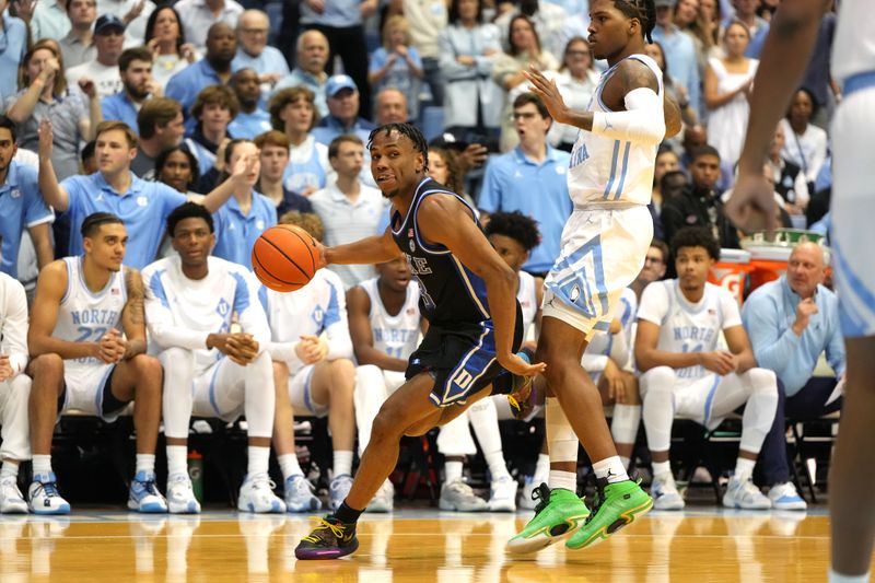 Mar 4, 2023; Chapel Hill, North Carolina, USA;  Duke Blue Devils guard Jeremy Roach (3) dribbles as North Carolina Tar Heels guard Caleb Love (2) defends in the first half at Dean E. Smith Center. Mandatory Credit: Bob Donnan-USA TODAY Sports