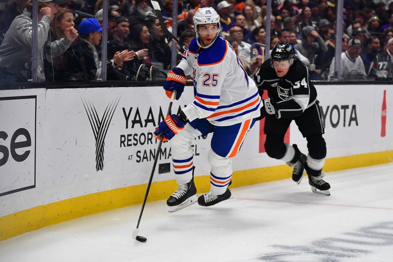 Dec 30, 2023; Los Angeles, California, USA; Edmonton Oilers defenseman Darnell Nurse (25) moves the puck ahead of Los Angeles Kings right wing Arthur Kaliyev (34) during the second period at Crypto.com Arena. Mandatory Credit: Gary A. Vasquez-USA TODAY Sports