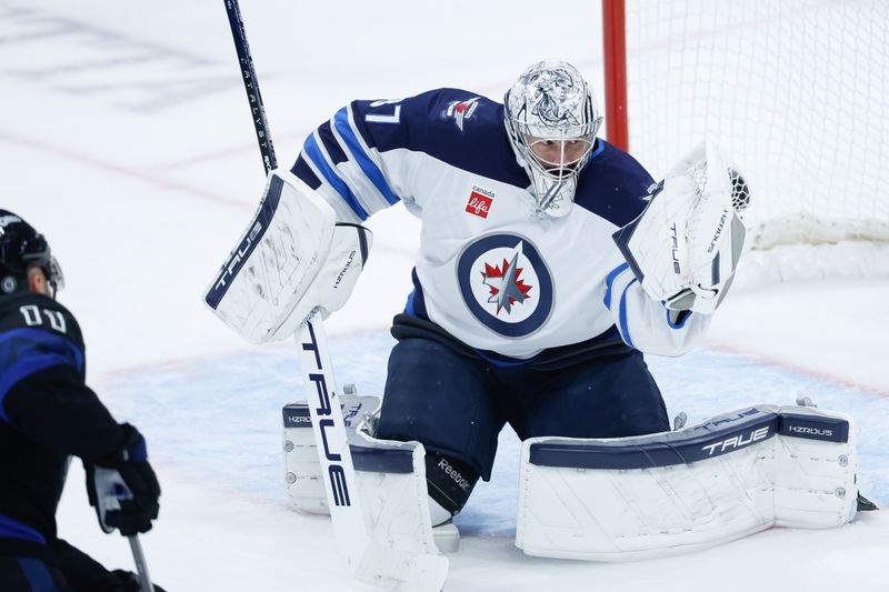 Oct 28, 2024; Winnipeg, Manitoba, CAN;  Winnipeg Jets goalie Connor Hellebuyck (37) makes a save on a shot by Toronto Maple Leafs forward Max Domi (11) during the third period at Canada Life Centre. Mandatory Credit: Terrence Lee-Imagn Images