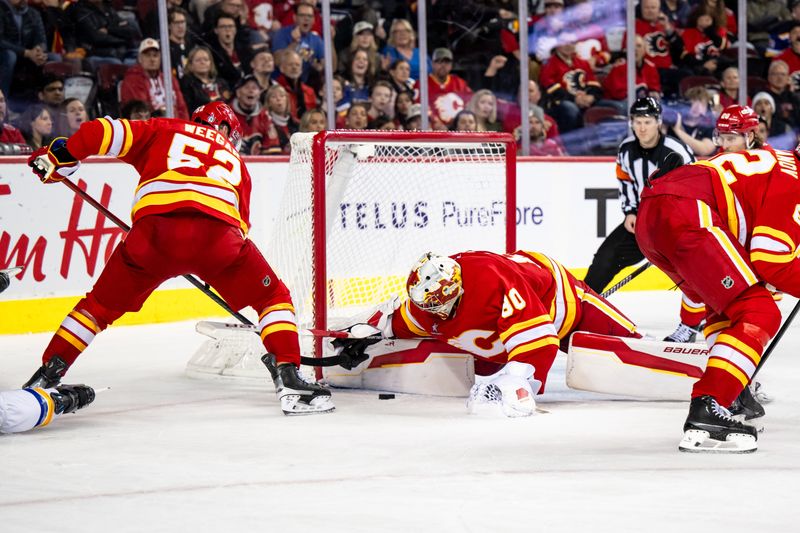 Dec 5, 2024; Calgary, Alberta, CAN; Calgary Flames goaltender Daniel Vladar (80) covers the puck after stopping a St. Louis Blues shot during the third period at Scotiabank Saddledome. Mandatory Credit: Brett Holmes-Imagn Images