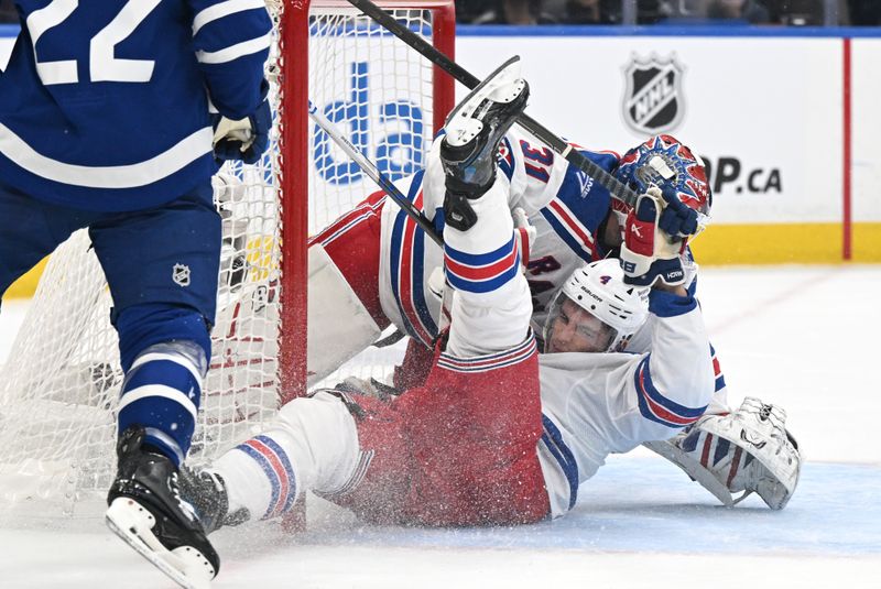 Oct 16, 2025; Toronto, Ontario, CAN; New York Rangers defenseman Braden Schneider (4) collides with goal Igor Shesterkin (31) in the first period against the Toronto Maple Leafs at Scotiabank Arena. Mandatory Credit: Dan Hamilton-Imagn Images