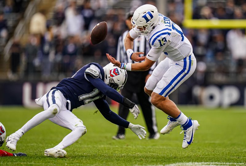 Sep 23, 2023; East Hartford, Connecticut, USA; Duke Blue Devils quarterback Riley Leonard (13) fumbles the ball under pressure from UConn Huskies defensive back Malcolm Bell (14) in the second quarter at Rentschler Field at Pratt & Whitney Stadium. Mandatory Credit: David Butler II-USA TODAY Sports