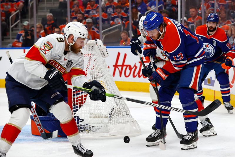 Jun 4, 2025; Edmonton, Alberta, CAN; Edmonton Oilers center Mattias Janmark (13) skates with the puck against Florida Panthers center Sam Bennett (9) during overtime in game one of the 2025 Stanley Cup Final at Rogers Place. Mandatory Credit: Perry Nelson-Imagn Images