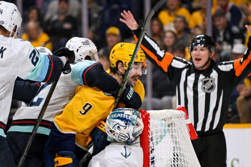 Oct 15, 2024; Nashville, Tennessee, USA;  Seattle Kraken defenseman Brandon Montour (62) grabs Nashville Predators left wing Filip Forsberg (9) during the first period at Bridgestone Arena. Mandatory Credit: Steve Roberts-Imagn Images